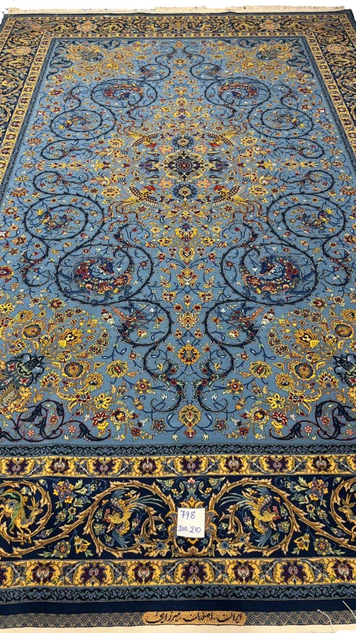 Luxurious blue Persian rug with intricate silk and wool patterns
